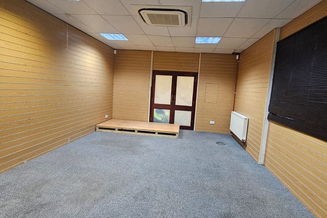 Sanctuary Hall, a calm room with warm wood panelling and a low platform.
