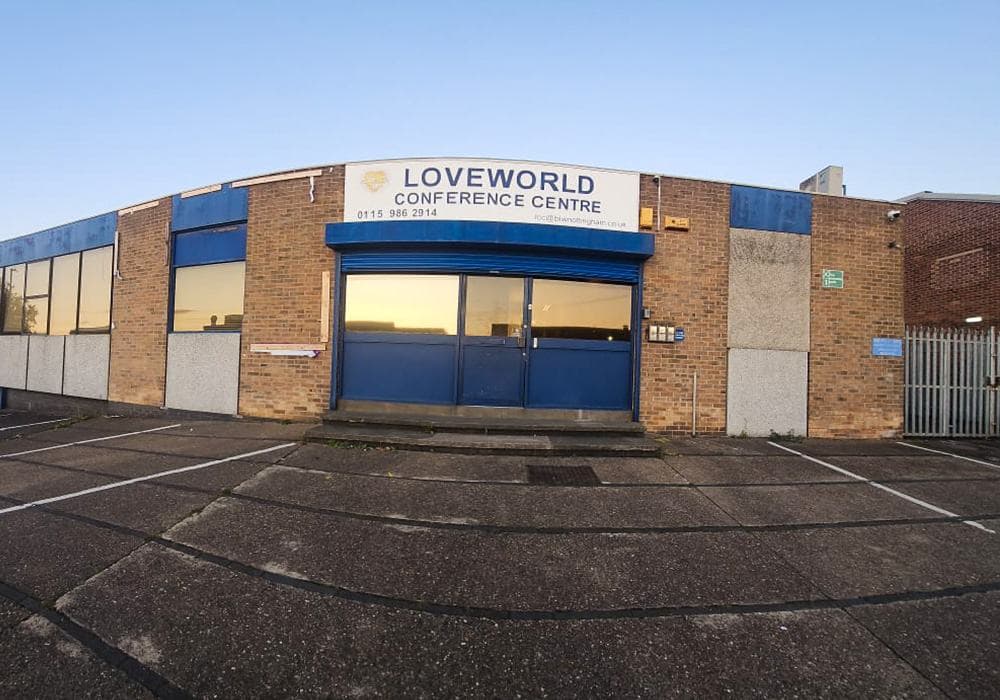The front of Loveworld Conference Centre on Palm St, with its blue entrance and car park.
